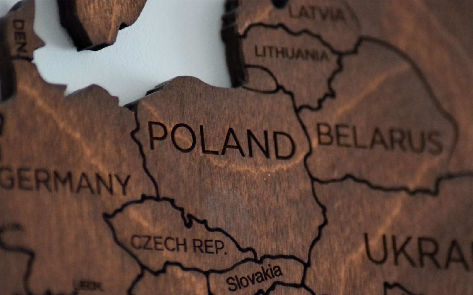 Close-up of a wooden map of Central Europe with Poland engraved in the middle, next to Germany, Lithuania and Belarus